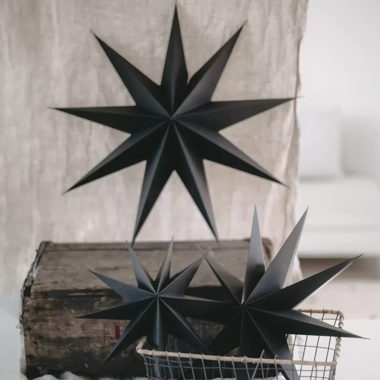 Two black paper stars of different sizes decoratively arranged on a wooden box.