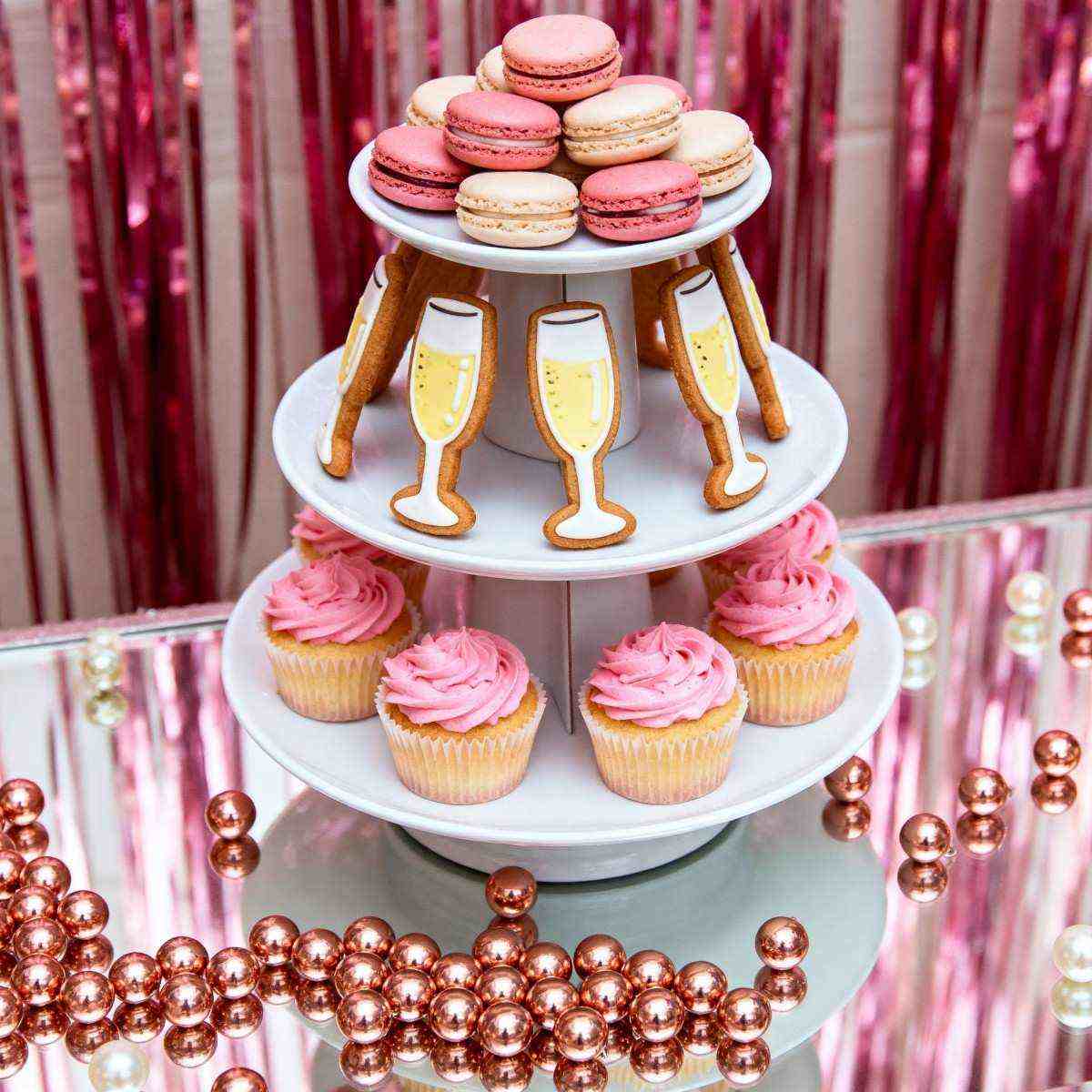 The dessert table for the bachelor party was decorated with a three-tiered cake stand featuring macaron towers, champagne glass-shaped cooki