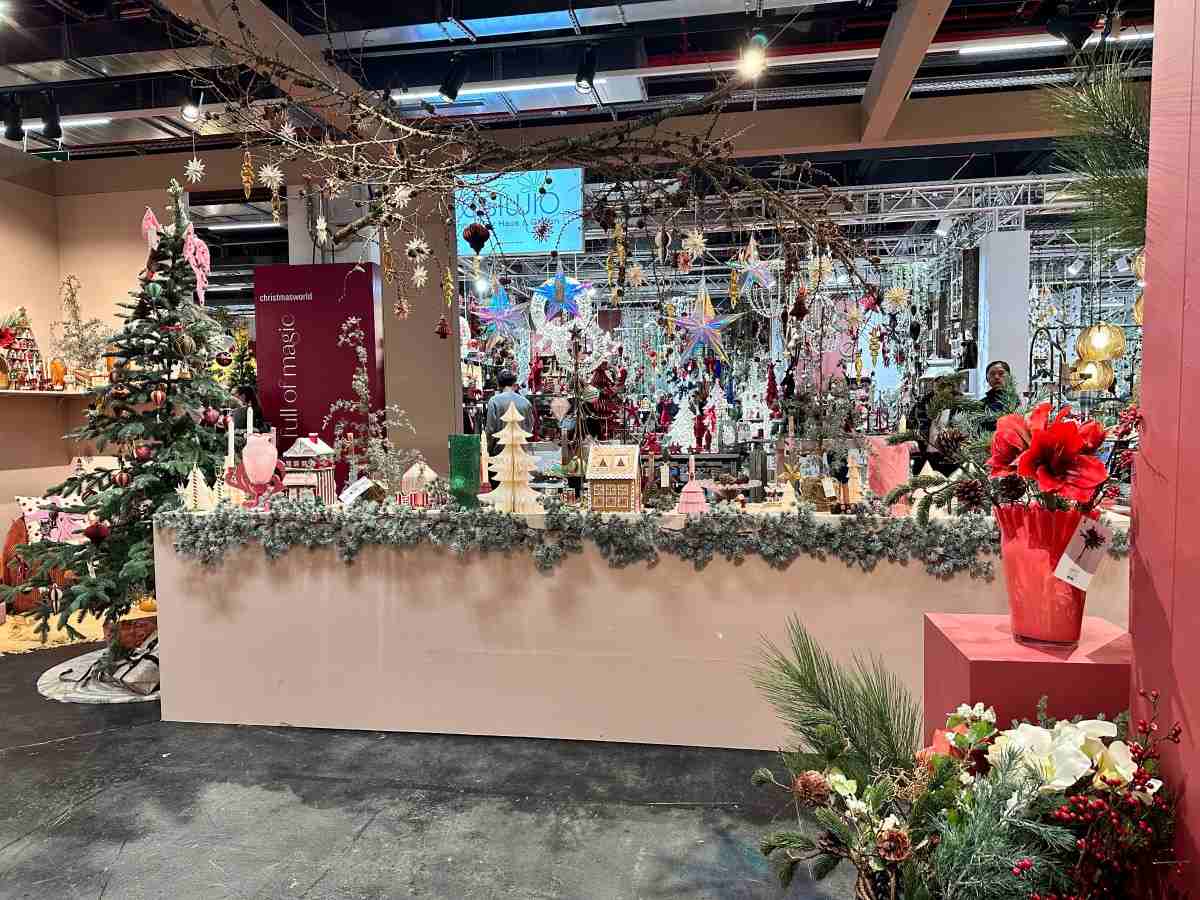 Christmas decoration stall at an indoor trade show with festive trees and ornaments