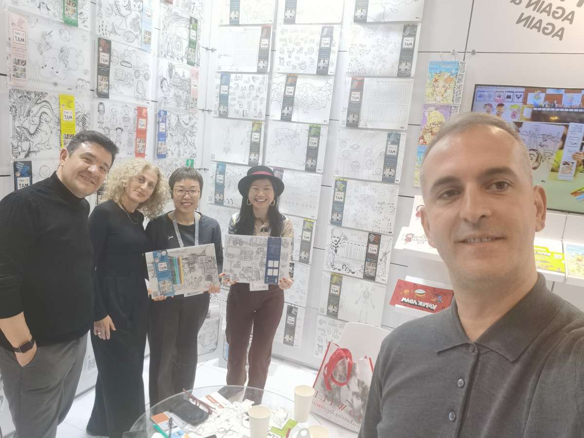 Diverse team posing with artwork samples at a creative exhibition booth