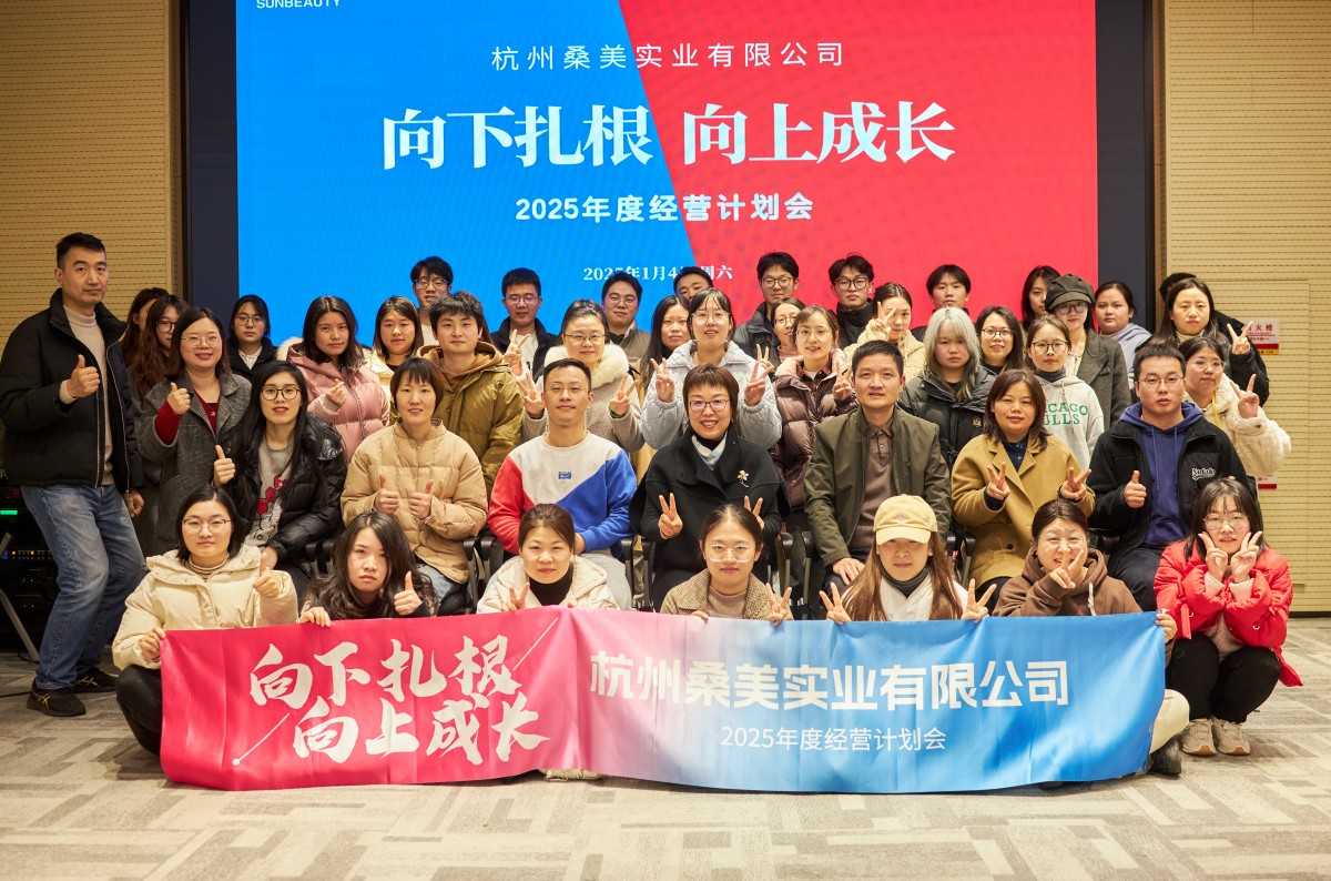 Team of Sunbeauty posing with a banner reading 'Root down, grow up'