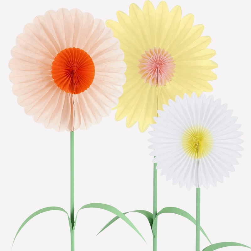 Close-up of three pastel paper daisy decorations