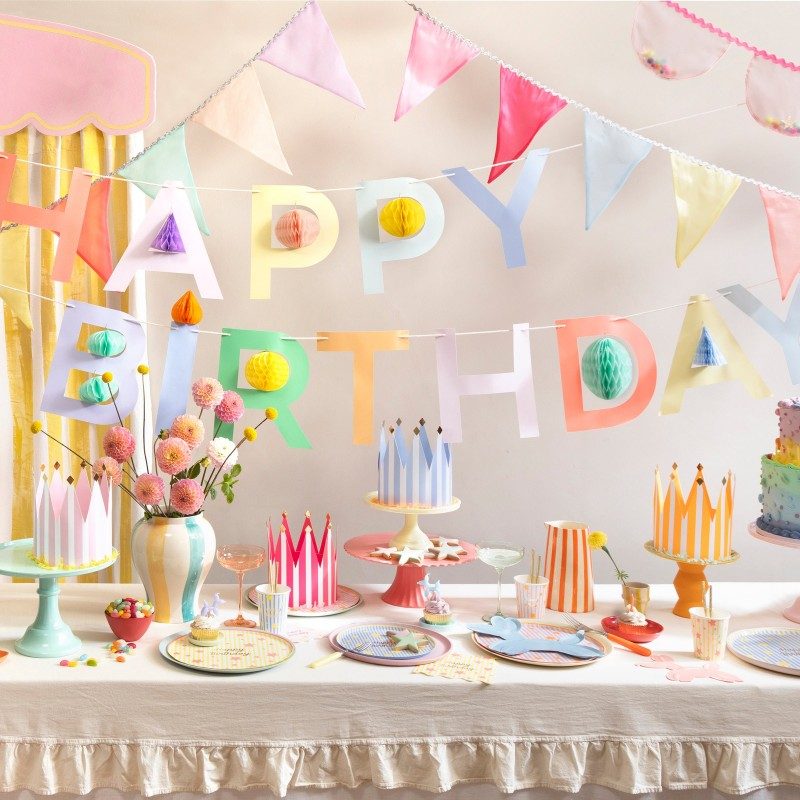 Pastel-themed birthday party table with 'Happy Birthday' decor