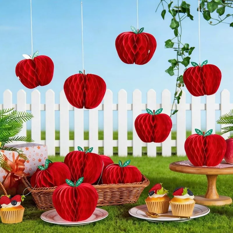 Red apple honeycomb paper decorations, outdoor lawn harvest‑themed party styling