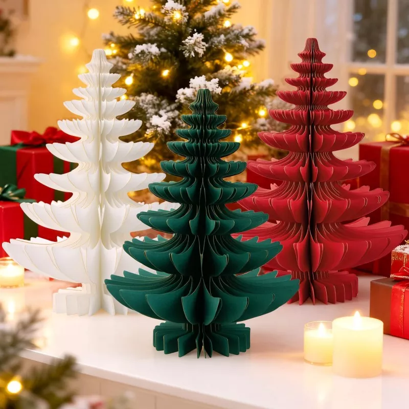 Red white green paper Christmas trees set on white table, gift boxes, candles and decorated Christmas tree in warm background
